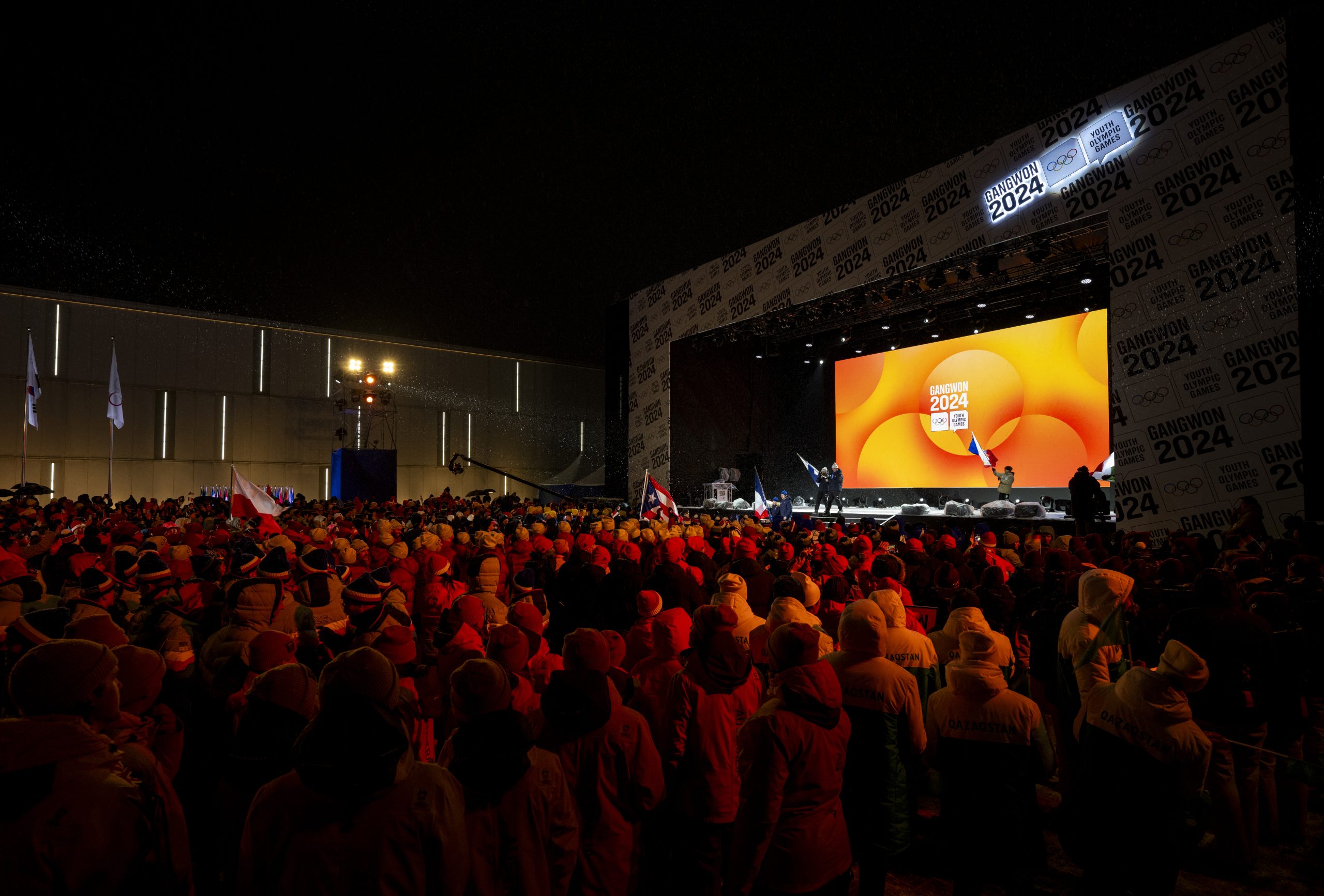 Athletes walk on to the stage with their national flags from Finland and France as spectators look on during the Closing Ceremony at the Gangneung Olympic Park.